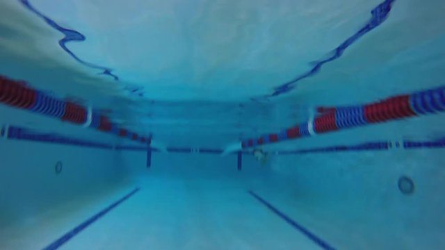 Underwater timelaspe FPV shot of man swimming breast stroke