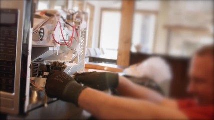 Appliance technician looks at microwave circuit boards