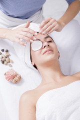 Young woman enjoying facial massage at spa salon