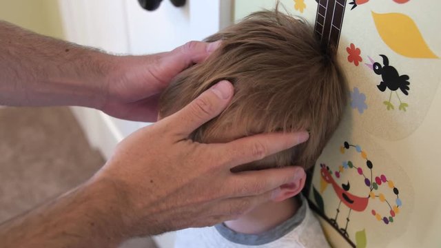 Father measures his toddler son against the wall