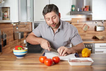 Fototapeta na wymiar Single man preparing fresh meal in his kitchen