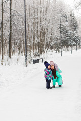 Fototapeta na wymiar Happy family. Mother and child girl on a winter walk in nature.