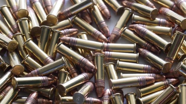 Dolly shot of pile of .22 ammunition bullets