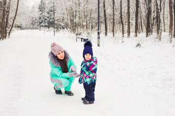 Fototapeta na wymiar Mother and daughter having fun in the winter park
