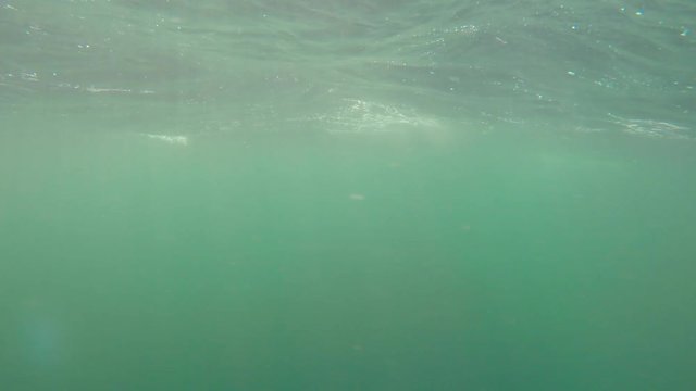 An underwater shot of large rough ocean waves on the surface