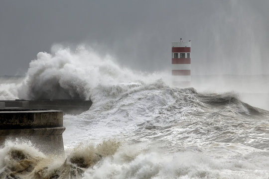 Pier and beacon covered by stormy waves