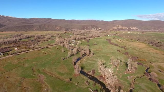 Aerial shot of the river in fields and town in springtime