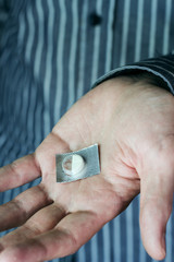 Fototapeta premium Mano de hombre sosteniendo media pastilla 