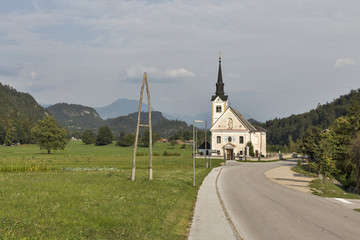 Fototapeta na wymiar Traditional catholic church in Bohinjska Bela village near Bled, Slovenia.