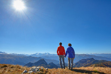 Naklejka premium active hikers hiking enjoying view looking at mountain landscape 