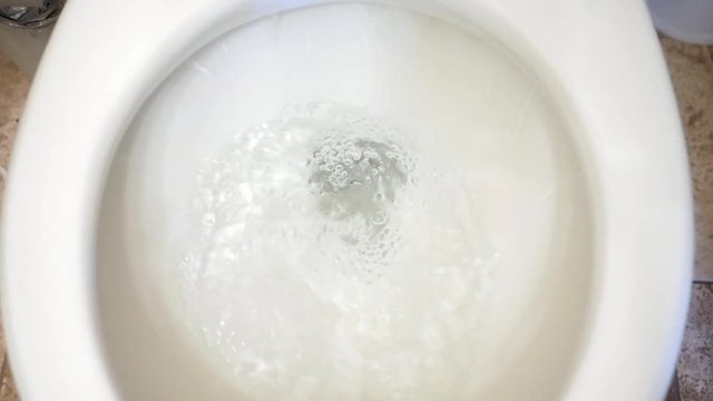 Slow motion water flushing down the toilet