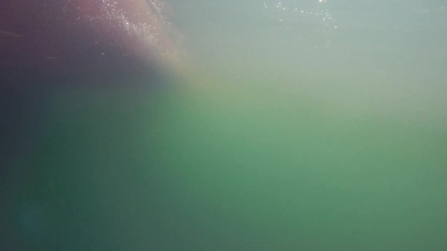 An underwater shot of bubbles passing by on the bottom of boat