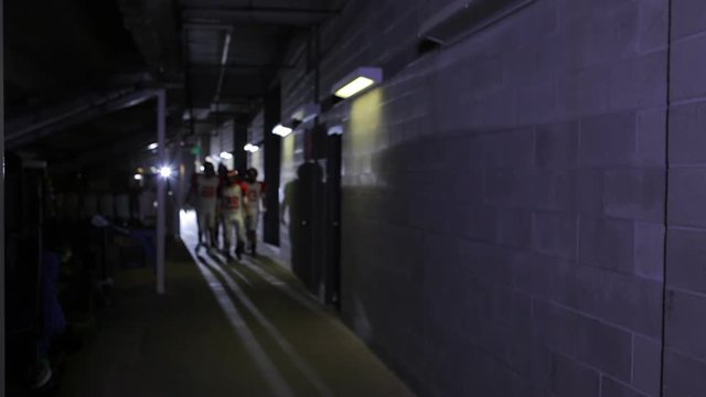 Football players walk down the tunnel before the game