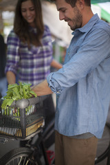 Young couple shopping for flowers and produce at a farmer's market in San Diego, California.