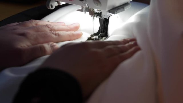 A woman uses sewing maching in her house