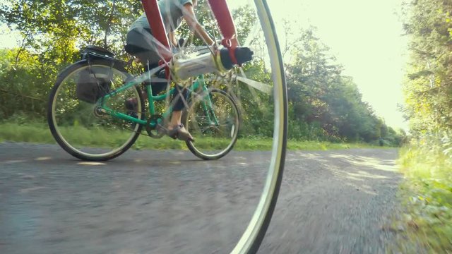 Fun shot of couple biking in a green forest on bike trail