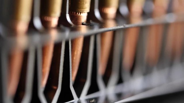 Dolly shot of large caliber ammunition in a production line