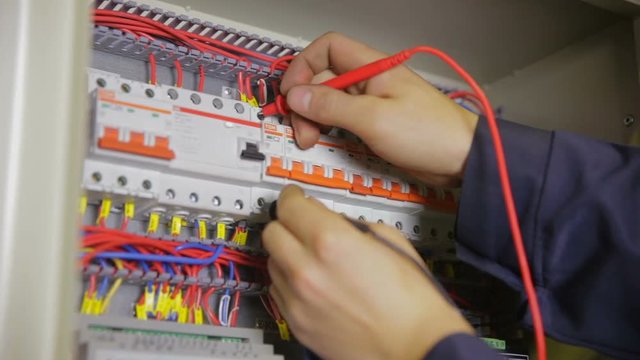 Electric Breaker Box. Electrician testing and switching fuse, breaker in a fuse box. HD.