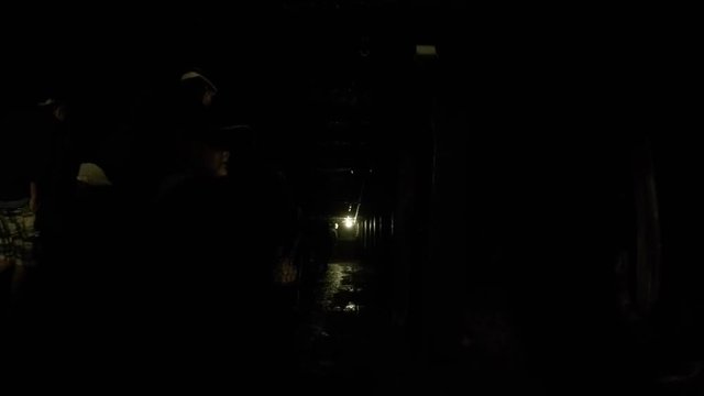 A camera moving shot through dark coal mine in glace bay with tourists families