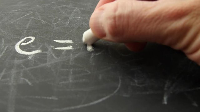 Man writes equation on chalkboard