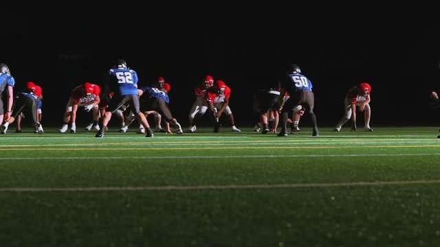 A football player runs past multiple defenders as he tries to score