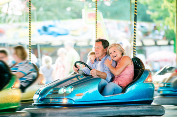 Senior couple in the bumper car at the fun fair