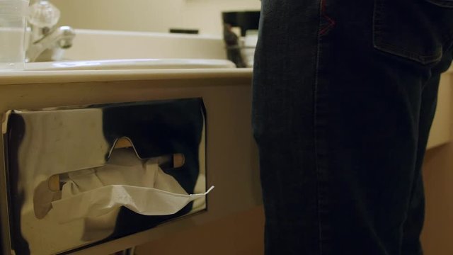 A man grabs kleenex while in a hotel room