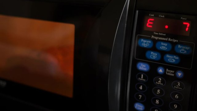 A microwave pizza cooking in a hotel room