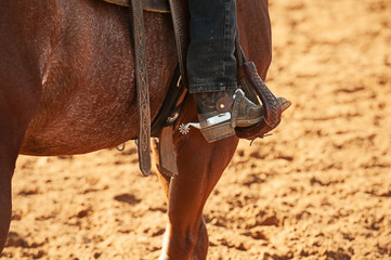 close-up of a spur og the horserider sitting on the horse with cowboy boot