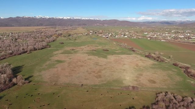 Aerial shot of a river in fields and town in springtime