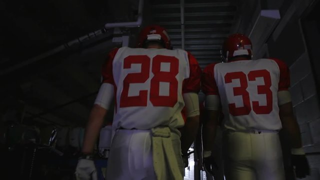 A football players walking down the tunnel to the field before a game