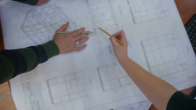 Engineers and architects discussing the blueprint at bright office. HD.