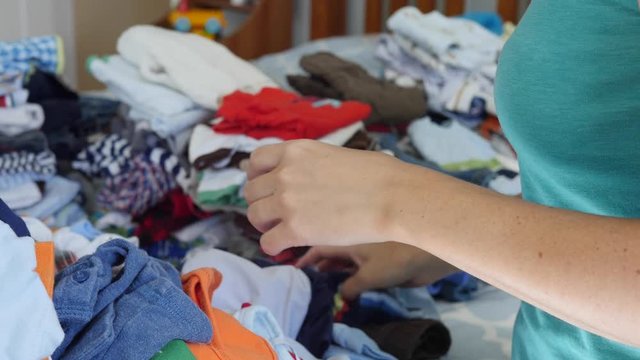 A young mother sorting through the kids clothes