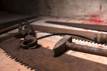 Close up of saws, sickles and other devices on the bloody floor