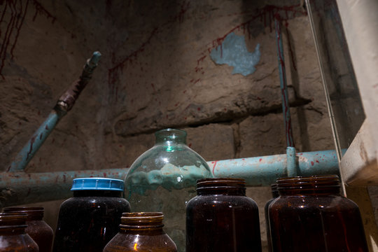 Terrible glass jars and bottles with blood spattered wall in sta