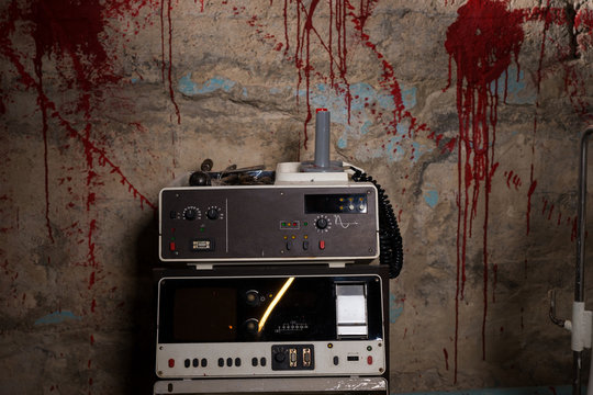Close up of electrical shocking device with blood stained wall