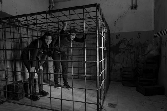 Black and white picture of victims imprisoned in a metal cage tr