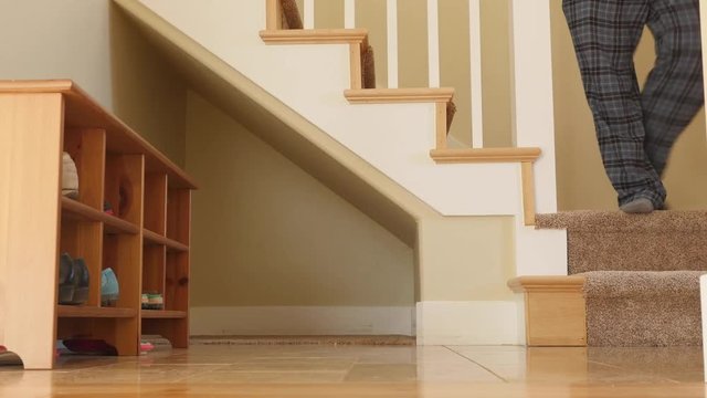 A man walks down house stairs from second level