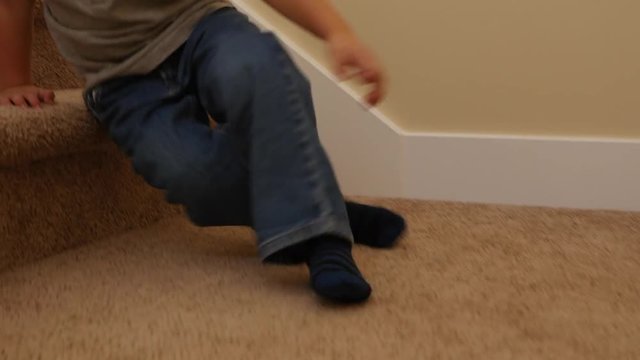 A cute little boy sliding down the stairs in a home
