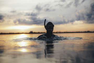 Male diver with snorkel mask submerged in sea