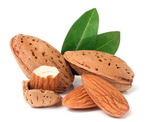 almonds in their skins and peeled with leaf isolated on white background