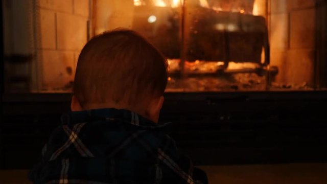Baby boy sitting by their home fireplace