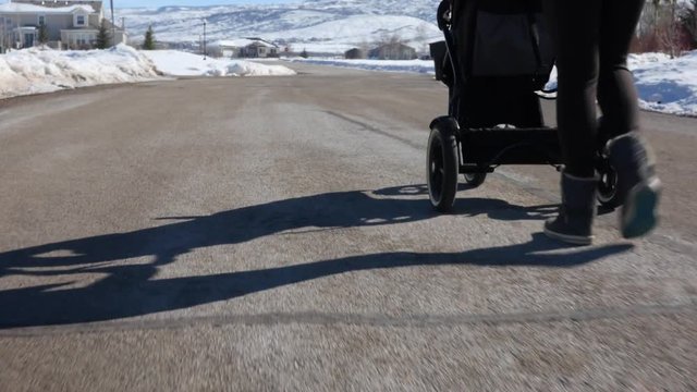 Woman walking her baby boy in stroller