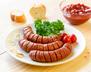 sausage and herbs served with tomato sauce and bread /roll on a wooden board