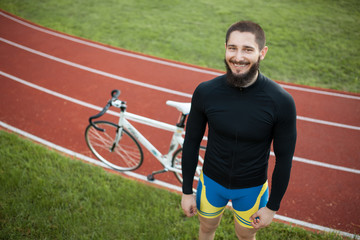 bearded cheerful bicycle rider on track;