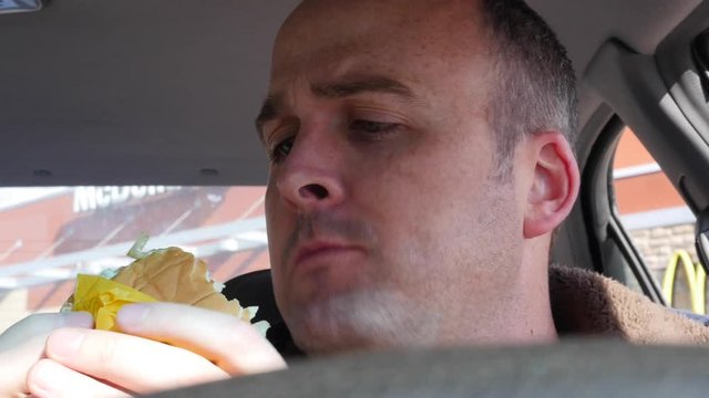 Man eating fast food in his car