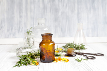 concept - natural medicine herbs in bottles on wooden background