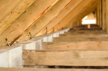 Raising roof truss to second story of new residential construction. Interior view of a wooden roof structure. roof preparation of OSB.