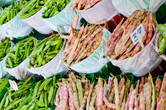 Green sugar snap peas and pink speckle shelling cranberry beans display for sale at farmers market