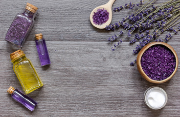 cosmetic creams with lavender flowers on black wooden table